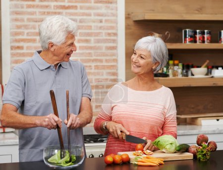 Photo for Cooking, health and help with old couple in kitchen for salad, love and nutrition. Happy, smile and retirement with senior man and woman cutting vegetables at home for food, dinner and recipe. - Royalty Free Image