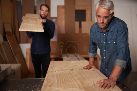 Photo for Carpentry, carpenter and men in team in workshop, design project with vocation and creative DIY skill. Teamwork, collaboration and male employee with wood beam, father and son working together. - Royalty Free Image