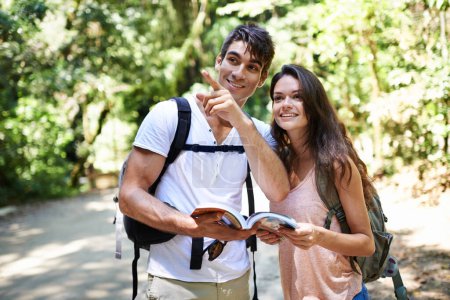 Photo for Lets go explore that way. a young couple looking at a guidebook while out hiking - Royalty Free Image