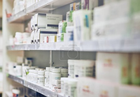 Closeup, pharmacy and medicine with healthcare, pills and shelf with boxes, bottles and treatment. Zoom, medication and package with container, retail and store with pharmaceutical, items or products.