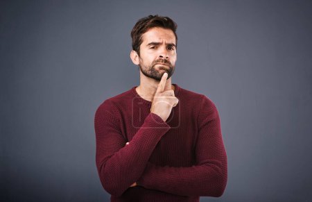 Photo for Doubt, thinking and portrait of man in studio with unsure, uncertain and thoughtful on gray background. Confused, mockup space and face of male person skeptical for decision, choice and question. - Royalty Free Image