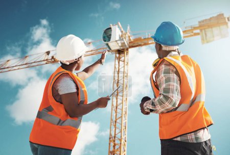 Photo for Construction, engineering and team with tablet and crane for building project, teamwork or architecture. Black woman and man manager talking outdoor for engineer planning, vision or safety inspection. - Royalty Free Image