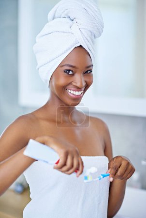 Téléchargez les photos : Assurez-vous que votre sourire avec ce dentifrice génial. une belle jeune femme lors de sa routine beauté quotidienne - en image libre de droit