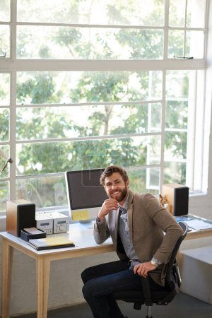 Téléchargez les photos : Confiant et créatif. Portrait d'un bel homme d'affaires travaillant dans son bureau - en image libre de droit