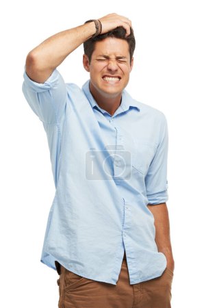 Photo for Forgetful and regretful. A handsome young man holding his head in frustration against a white background - Royalty Free Image