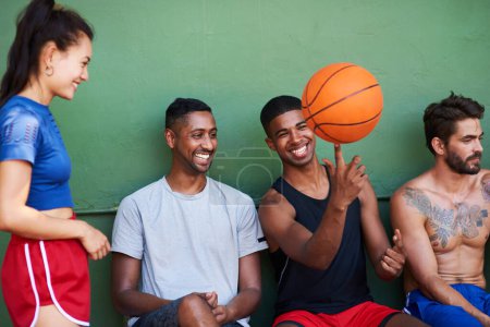 Photo for Watch this. a group of sporty young people taking a break after a game of basketball - Royalty Free Image