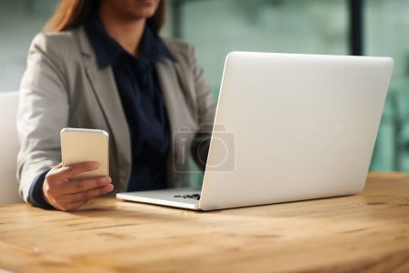 Photo for Phone, laptop or hands of woman in office on social media networking, chatting or texting message. Business news, scroll or editor typing, copywriting or checking emails online on digital mobile app. - Royalty Free Image