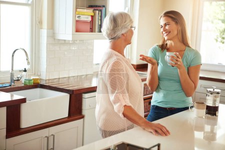 Photo for Mother, coffee or happy woman chatting in kitchen in family home bonding or enjoying quality time together. Smile, retirement or daughter talking, relaxing or drinking tea with senior parent on break. - Royalty Free Image