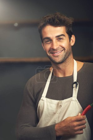 Photo for Chef, hot pepper and portrait of man in kitchen with vegetables for vegetarian, healthy diet or vegan ingredients. Smile, male cook holding chilli and food for spices from Norway for cooking in home. - Royalty Free Image