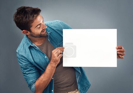 Photo for Man, billboard sign and mockup for marketing, advertising or branding against a grey studio background. Male person holding rectangle shape poster or placard for advertisement message with copy space. - Royalty Free Image