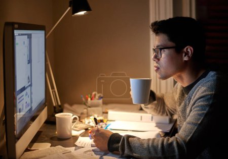Téléchargez les photos : Jeune, homme et étudiant étudiant étudiant la nuit sur un ordinateur de bureau dans une chambre. Collège, hommes et elearning à l'appartement avec café pour étudier avec la technologie et l'Internet pour l'éducation à l'université - en image libre de droit