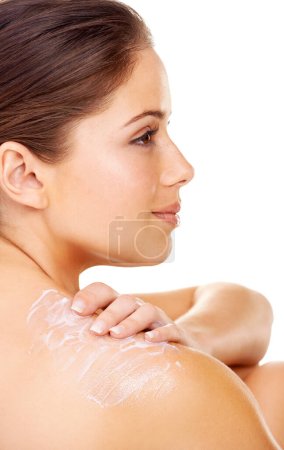Foto de Manteniendo mi piel en hermosa forma. Perfil de una joven morena aplicando loción en el hombro - Imagen libre de derechos