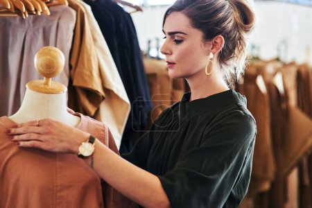 Photo for I make sure that all my pieces are flawless. a young fashion designer working on a garment hanging over a mannequin - Royalty Free Image