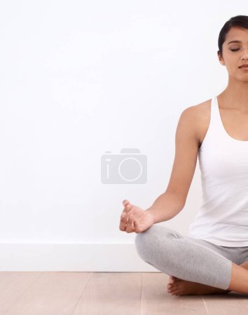 Photo for A moment of Tranquility. A beautiful young woman in the lotus position - Royalty Free Image