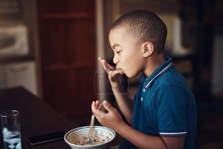 Foto de Los espaguetis de mi madre están lamiendo bien los dedos. un niño comiendo un tazón de espagueti en casa - Imagen libre de derechos
