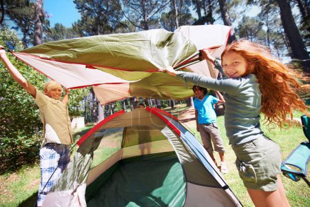 Happy children, portrait and tent setup in camping forest for shelter, cover or insurance together on the grass in nature. Kids in teamwork setting up tents for camp adventure or holiday in the woods.