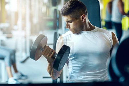 Photo for Its You VS. You. a man doing a upper-body workout at the gym - Royalty Free Image
