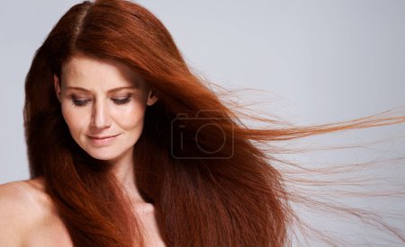 Photo for Hair care, red head and woman with wind for keratin treatment, wellness and beauty on white background. Salon, hairdresser and female model face with shine, healthy and natural hairstyle in studio. - Royalty Free Image