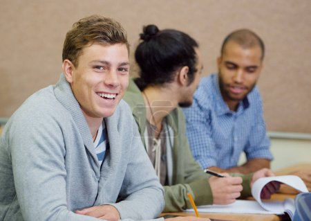 Foto de Estudiamos mucho, pero también nos reímos. estudiantes universitarios varones sentados en una sala de examen - Imagen libre de derechos