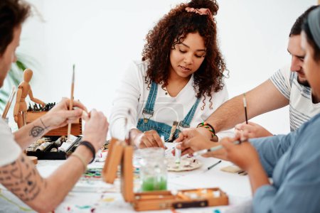 Photo for A sense of belonging lives within art. a diverse group of artists sitting together and painting during an art class in a studio - Royalty Free Image