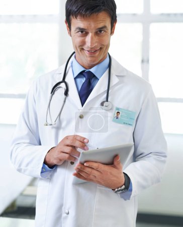 Photo for Would you like to know more. Portrait of a handsome young doctor using a tablet - Royalty Free Image