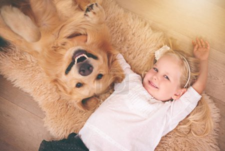 Girl, dog and portrait together on floor in living room or golden retriever, kid and smiling with pet above lounge carpet. Young child, Labrador and happiness or family home, pets and top view.