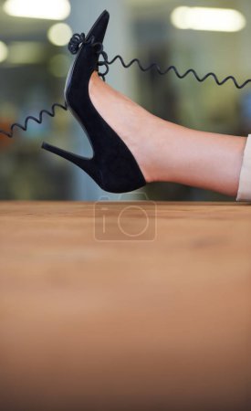 Foto de Negocios en stilettos. Imagen recortada de un cable telefónico envuelto alrededor de un estilete de mujer - Imagen libre de derechos