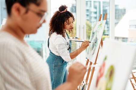 Photo for We lose ourselves through art. an attractive young woman standing with her friend and painting during an art class in the studio - Royalty Free Image