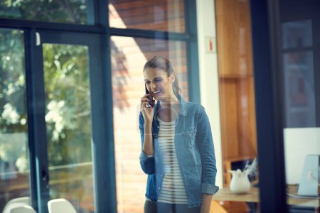 Photo for Thank you for calling me back. a young businesswoman using a mobile phone in a modern office - Royalty Free Image