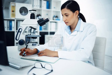 Photo for To summarise, its been solved. a young scientist writing notes while conducting medical research in a laboratory - Royalty Free Image