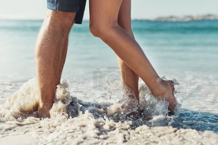 Photo for Its not summer until you get your feet wet. an unrecognizable couple standing together by the waters edge at the beach - Royalty Free Image