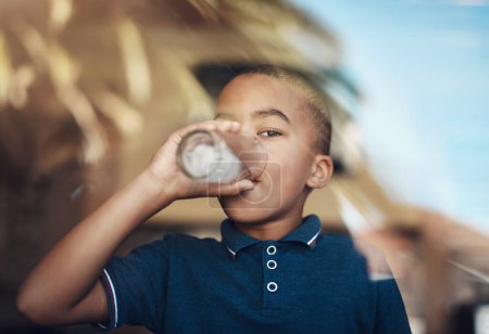 Foto de Necesito un poco de agua. un niño bebiendo un vaso de agua en casa - Imagen libre de derechos