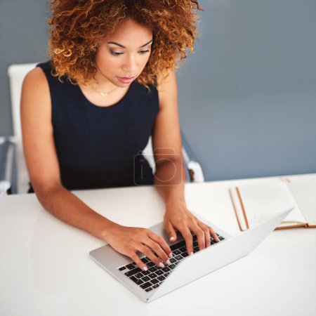 Making important connections on the wireless business network. a young businesswoman working on a laptop at her desk Poster 657537270