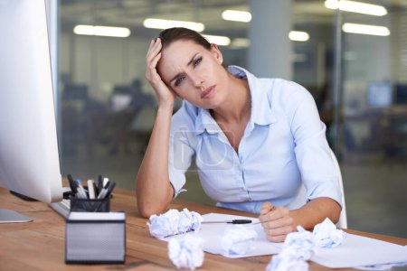 Photo for Whens this day going to end. Portrait of a stressed out businesswoman sitting at her desk - Royalty Free Image