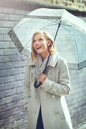 Téléchargez les photos : Parapluie, pluie de la ville et femme excitée avec bonheur sur un trottoir par temps hivernal. Bonne femme, pluie et voyage sur une route urbaine en plein air au Cap en vacances avec liberté et joie. - en image libre de droit