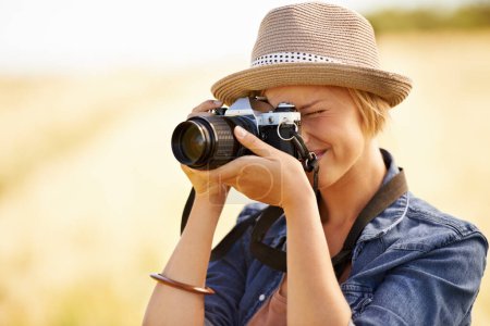 Téléchargez les photos : Capturer la nature. Une jolie jeune femme prenant des photos de la nature - en image libre de droit