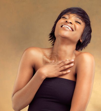 Foto de Tómate tu tiempo para reír. Estudio de una hermosa joven riendo sobre un fondo marrón - Imagen libre de derechos