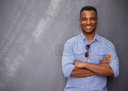 Foto de Confianza casual. Un joven guapo apoyado en una pared azul - Imagen libre de derechos