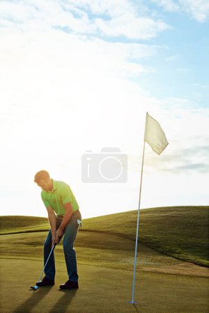 Téléchargez les photos : Calme-toi et tire. un jeune homme passe la journée sur un terrain de golf - en image libre de droit