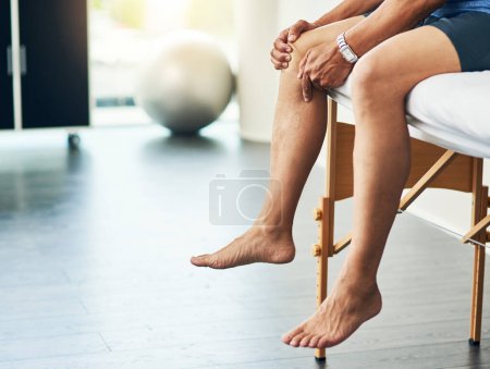 Photo for Physiotherapy, leg pain and medical with man in room for consulting, medical and training. Rehabilitation, muscle and injury with closeup of senior patient in clinic for physical therapy and healing. - Royalty Free Image