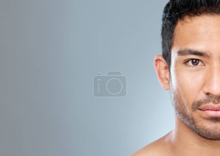 Téléchargez les photos : Les hommes peuvent aussi avoir une peau sensible. un beau jeune homme posant sur un fond gris - en image libre de droit