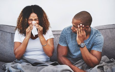 Téléchargez les photos : Je vais aussi être malade. un jeune homme irrité par sa petite amie souffrant d'allergies à la maison - en image libre de droit