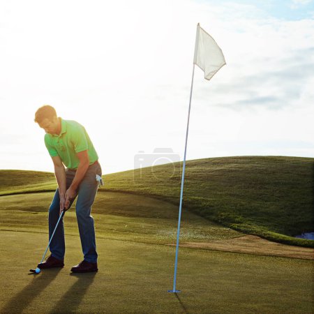 Foto de Su última jugada del día. un joven que pasa el día en un campo de golf - Imagen libre de derechos
