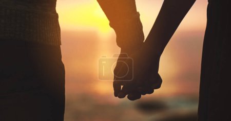 Photo for Holding hands, couple and sunset sky at beach with love on vacation, holiday or adventure. Man and woman silhouette outdoor to celebrate marriage, commitment and ocean travel or date in nature. - Royalty Free Image