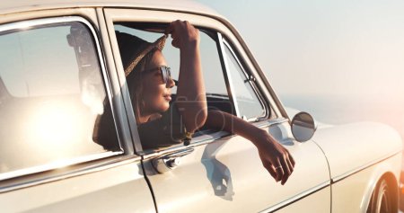 Photo for Road trip, window and flare with a woman in a car for travel, freedom or ride as a tourist on a coast in summer. Nature, sunset or vacation with a female traveler taking a drive outdoor for adventure. - Royalty Free Image