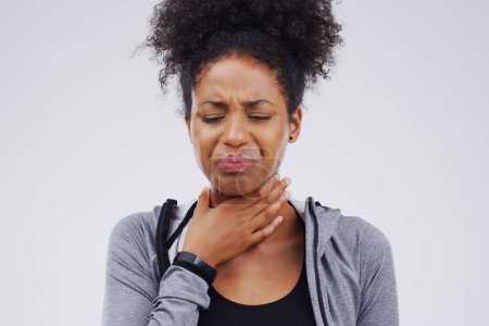 Black woman, sore throat and virus from cough, allergies or bacteria against a white studio background. Sick African female person touching neck in pain, allergy or flu of cold, illness or infection.