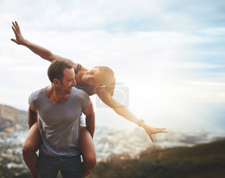 Photo for Travel, happy couple with piggyback ride and mountain outdoors with lens flare. Sunshine or mockup space, nature adventure or freedom and people playing on holiday break or summer vacation together - Royalty Free Image