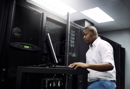 Photo for IT support, black man or coding on laptop in server room for big data, network glitch or digital website. Code, fixing or technician typing on computer testing UX, programming or software development. - Royalty Free Image