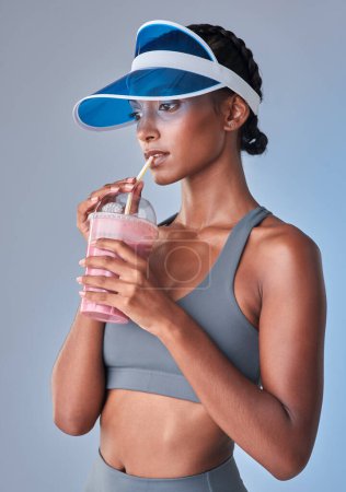 Photo for Goes down smooth, makes me feel good. Studio shot of a fit young woman having a healthy drink against a grey background - Royalty Free Image