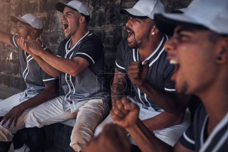 Foto de Los verdaderos fanáticos del deporte tienen pasión en sus corazones. un grupo de jóvenes viendo un partido de béisbol desde el dugout - Imagen libre de derechos